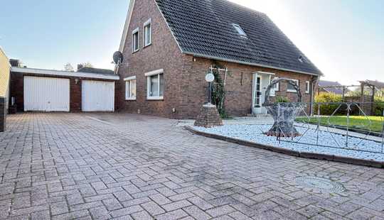 Bild von Einfamilienhaus mit großer Garage, Keller und Eigentumsgrundstück.