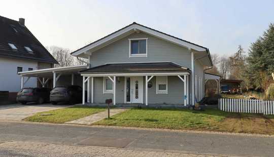 Bild von Modernes Holzbohlenarchitektenhaus am Feldrand mit Paddock und Reitplatz