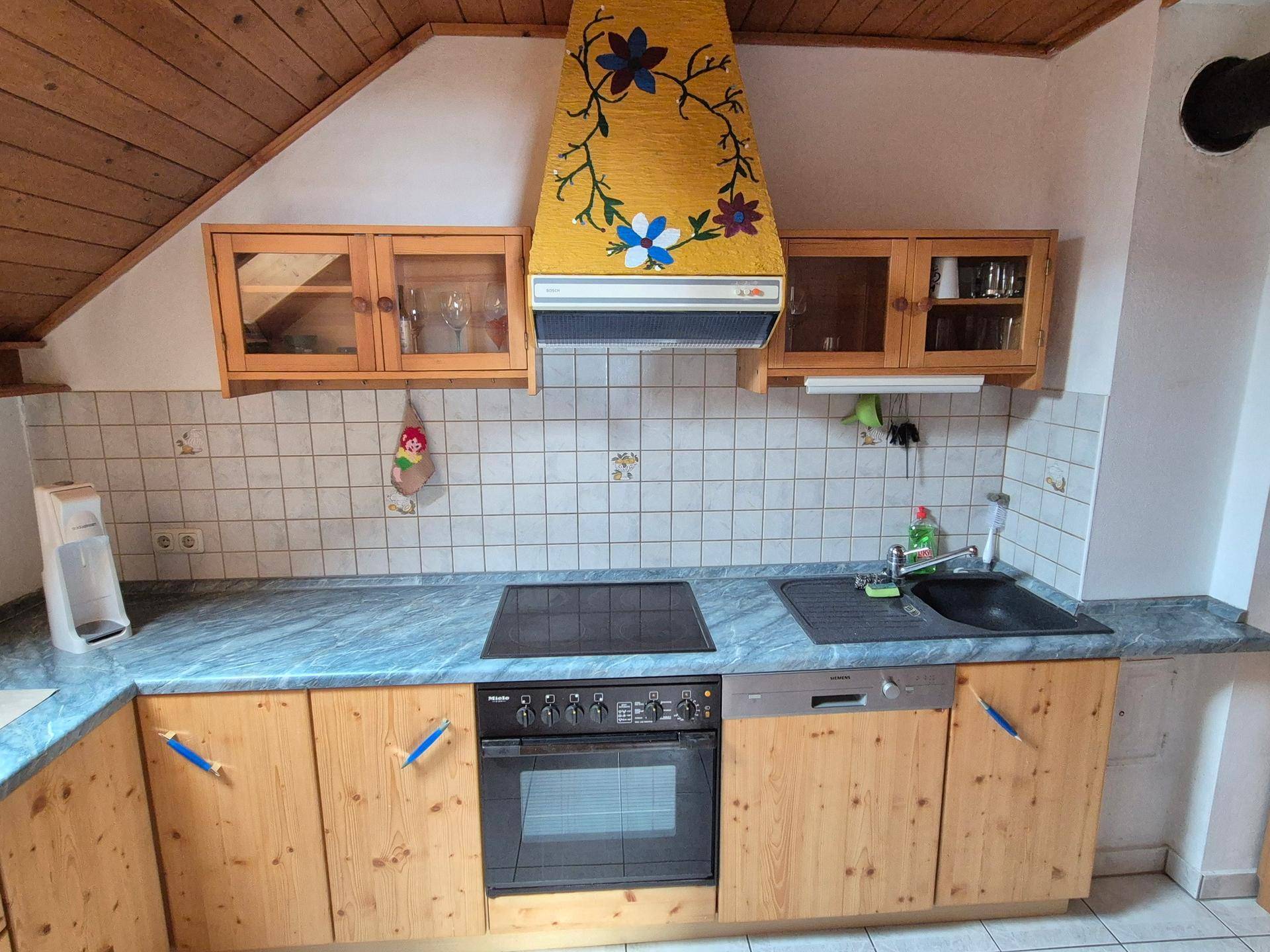 Traditionelle Küche mit Holzschränken, blauer Arbeitsplatte und weiß gefliestem Fliesenspiegel.