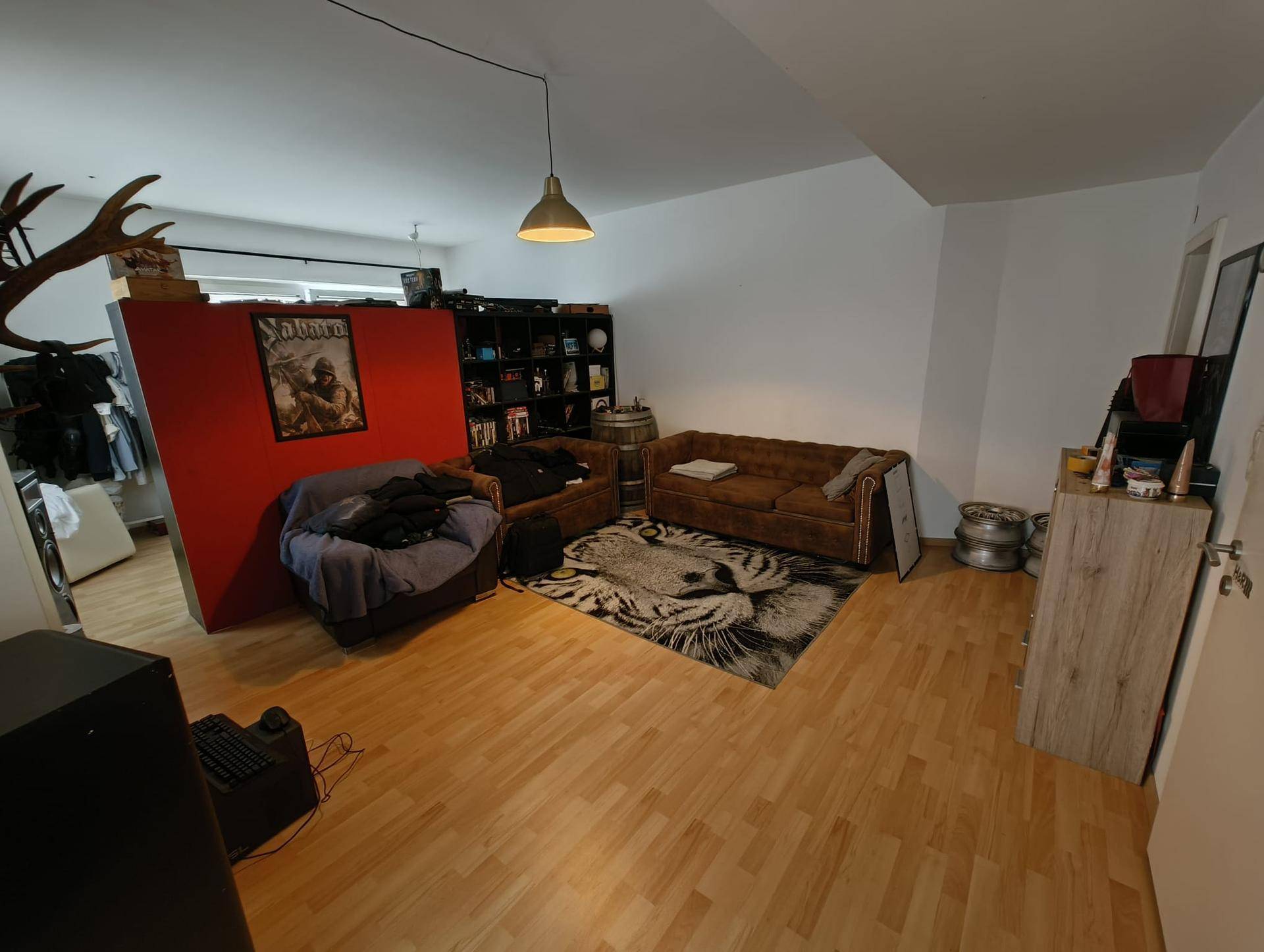 Helles Wohnzimmer mit Holzboden, gemütlichen Sofas und traditioneller Hirschgeweih-Dekoration.