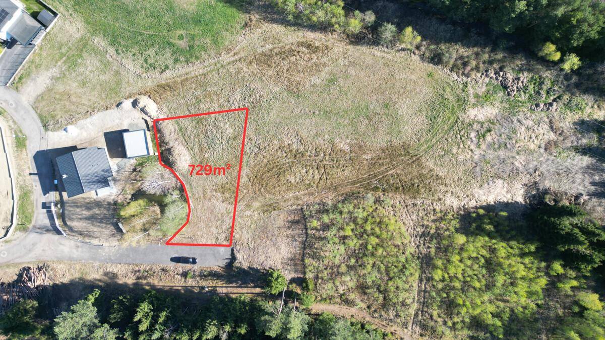 Luftbild des 729m² großen Baugrundstücks, umgeben von Grünflächen und weiteren Neubauten.