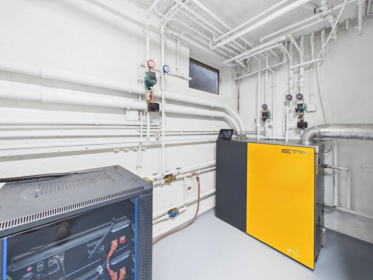 Heizungsraum mit moderner Heizungsanlage und sichtbaren Rohrleitungen.