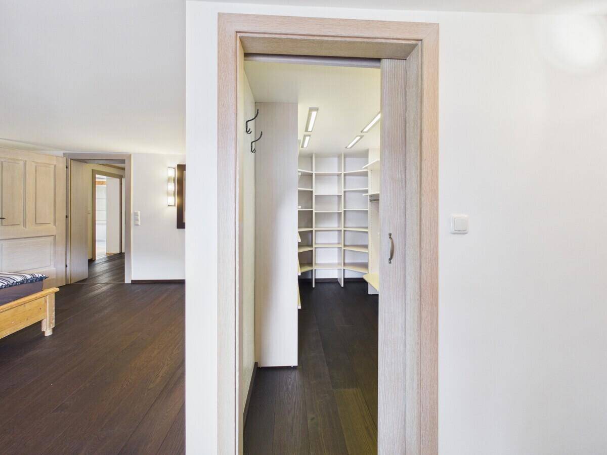 Begehbarer Kleiderschrank mit vielen Regalen und Stauraum, direkt vom Schlafzimmer zugänglich.