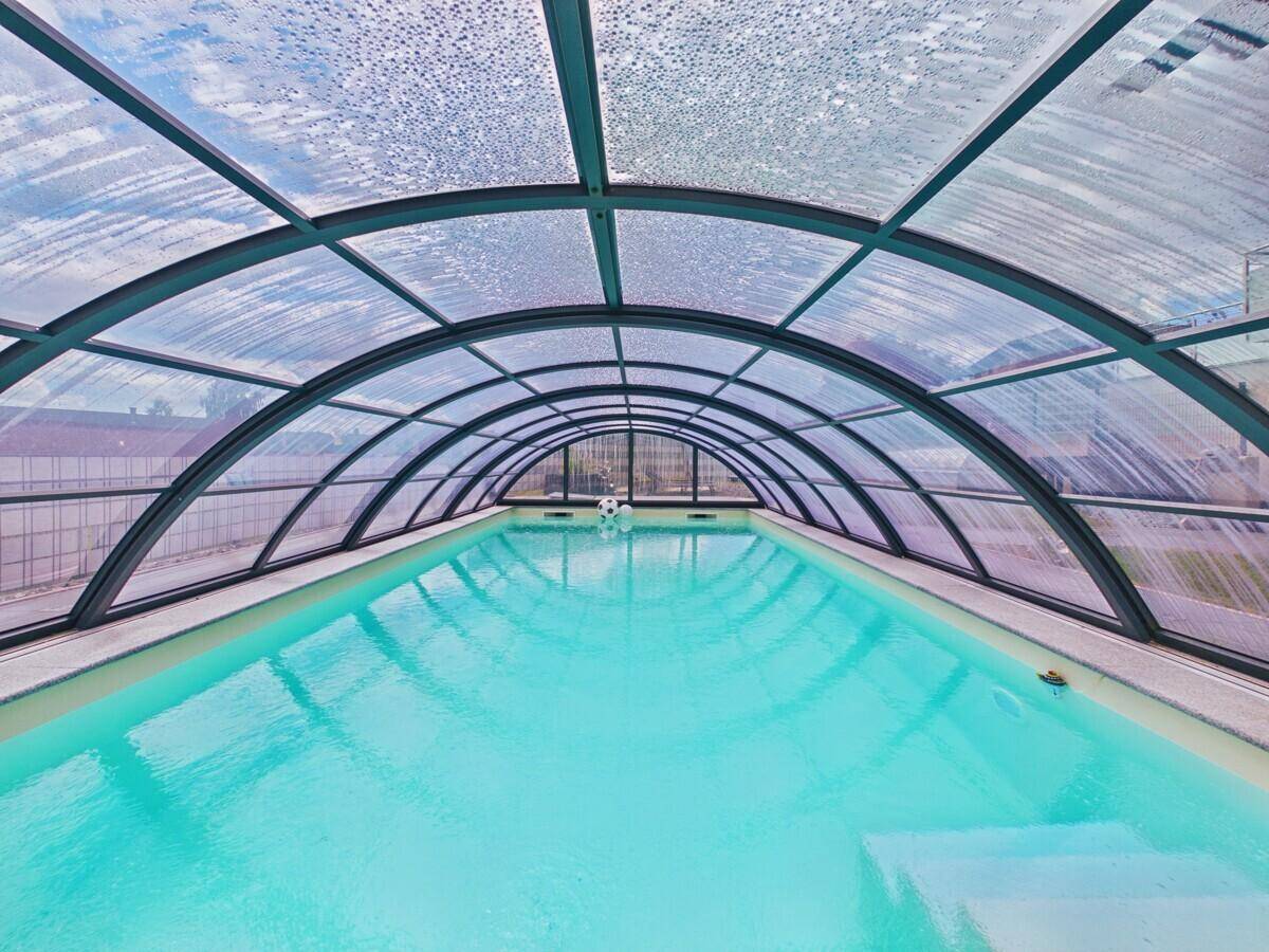 Überdachter Poolbereich mit klarem Wasser, ideal zum Schwimmen bei jedem Wetter.