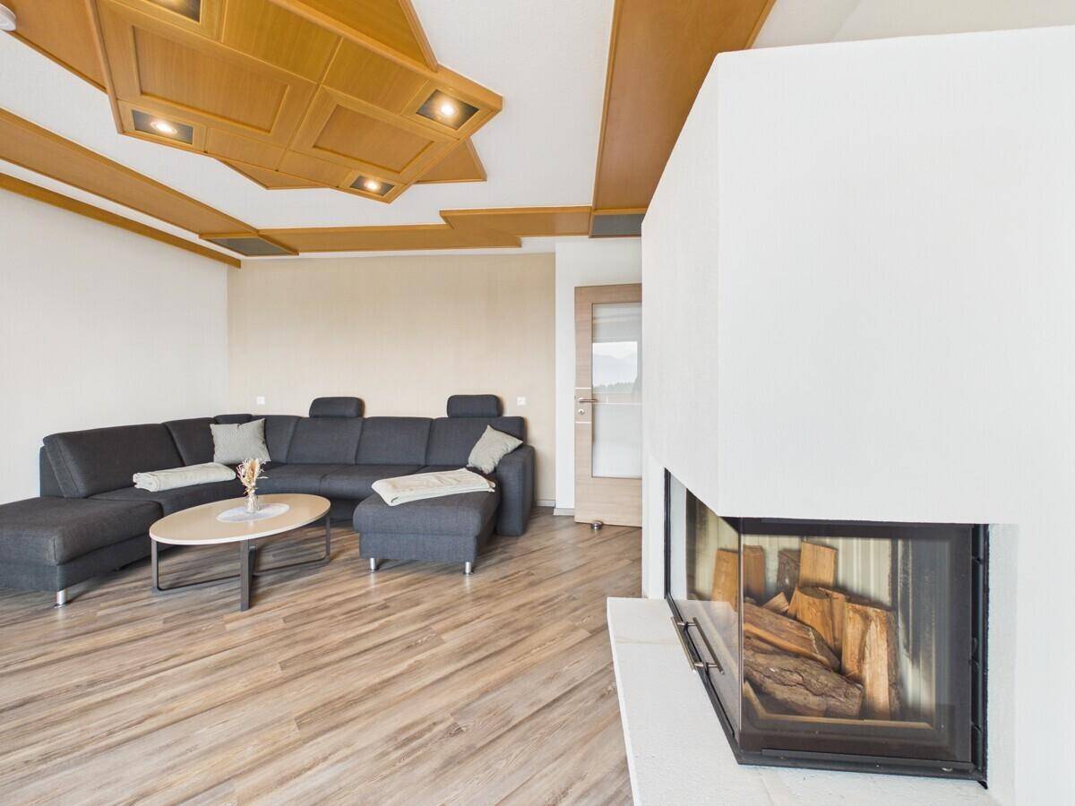 Moderner Kamin im Wohnzimmer, der eine gemütliche Atmosphäre schafft und Holzscheite zeigt.