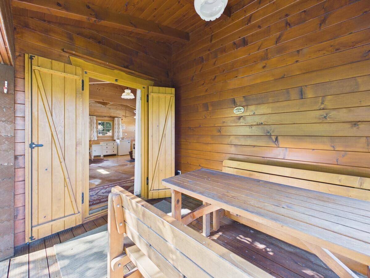 Blick von der überdachten Holzterrasse in den hellen Wohnbereich des Hauses.