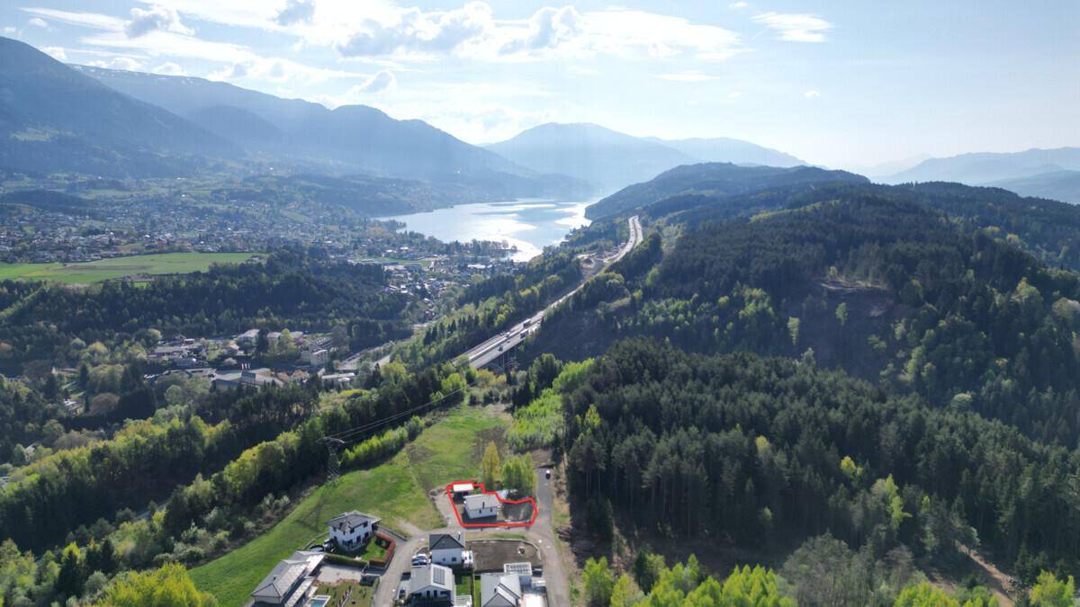 Luftaufnahme der Umgebung mit See und Bergen, ein Objekt ist rot umrandet.
