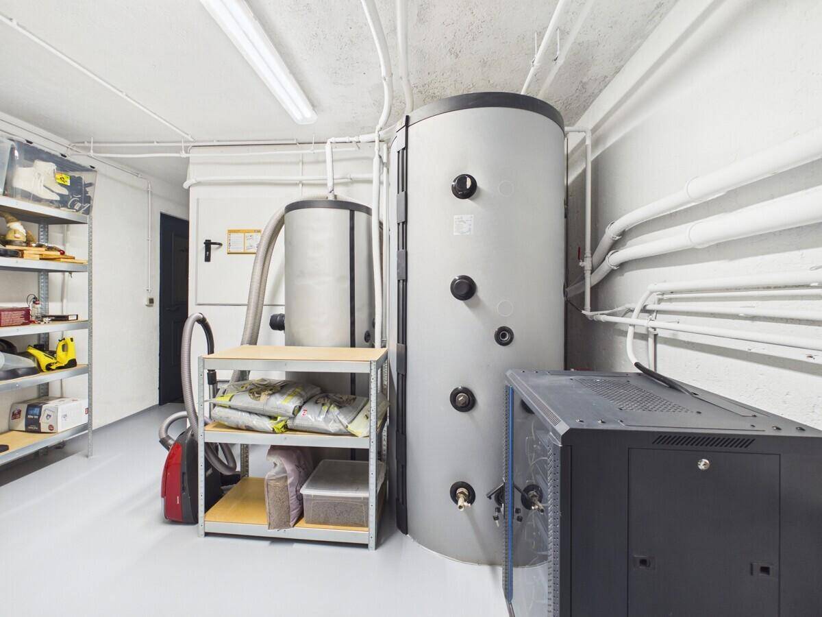 Geräumiger Abstellraum im Keller mit Warmwasserspeicher und Regalsystemen.