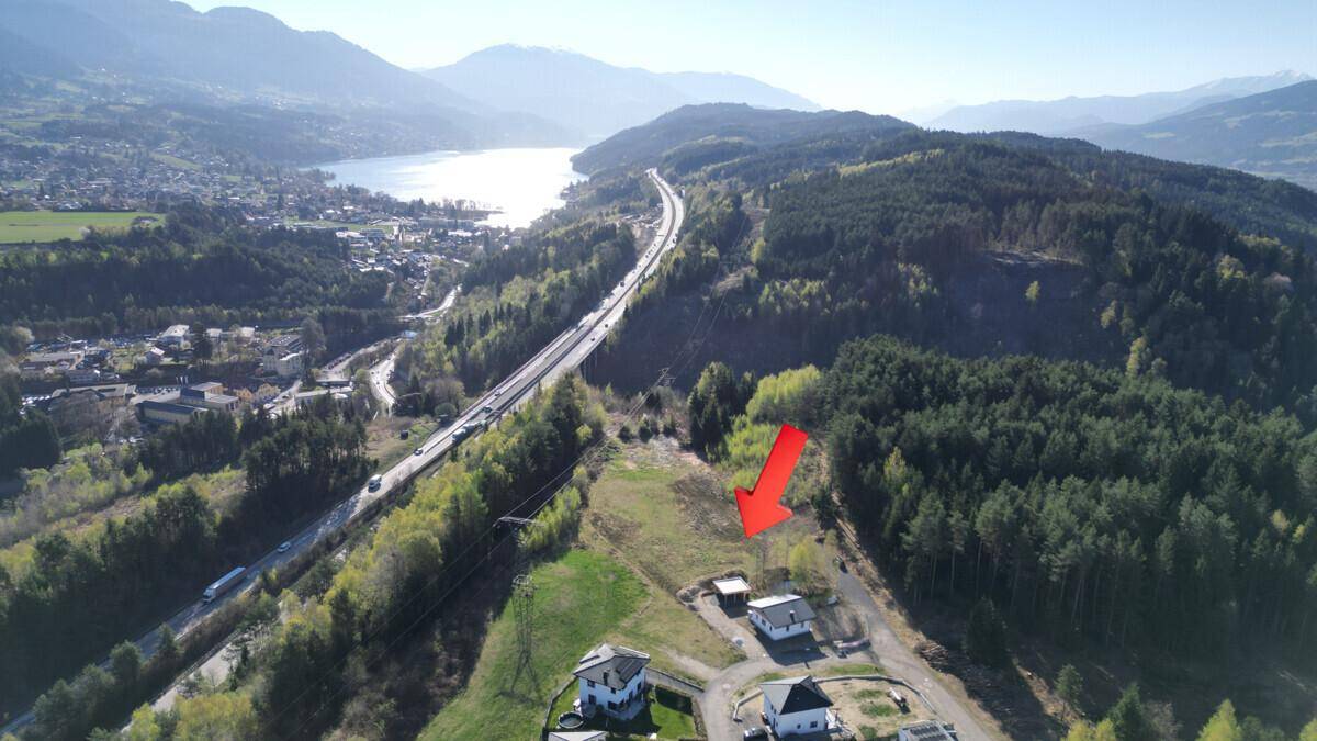 Luftaufnahme des Grundstücks mit umliegender Natur, See und Autobahn im Hintergrund.