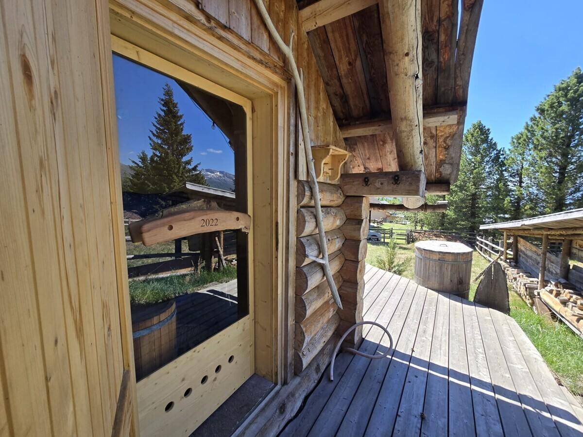 Eingangsbereich eines Holzhauses mit Terrasse und Blick auf die Berglandschaft.