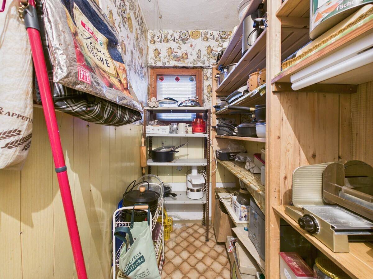 Praktische Speisekammer mit Regalen für Vorräte und Küchenutensilien, gut organisiert.
