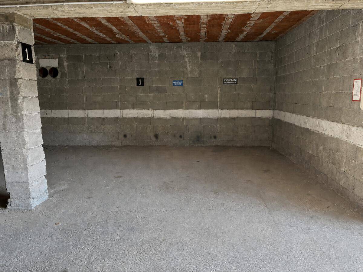 Leere Tiefgarage mit Betonwänden und -decke, bereit zur Nutzung.