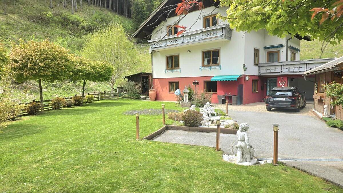 Idyllisches Anwesen mit weitläufigem Rasen, Auffahrt und traditioneller Architektur.