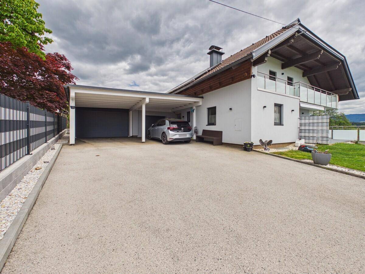Seitenansicht des Hauses mit Carport, Garage und großzügiger Zufahrt.
