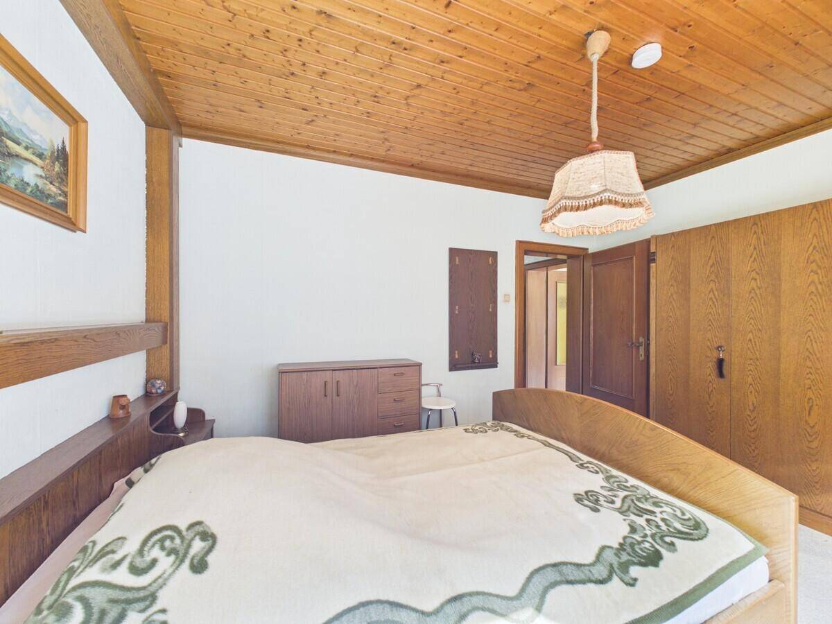 Schlafzimmer mit Doppelbett, Holzdecke und geräumigen Holzschränken.