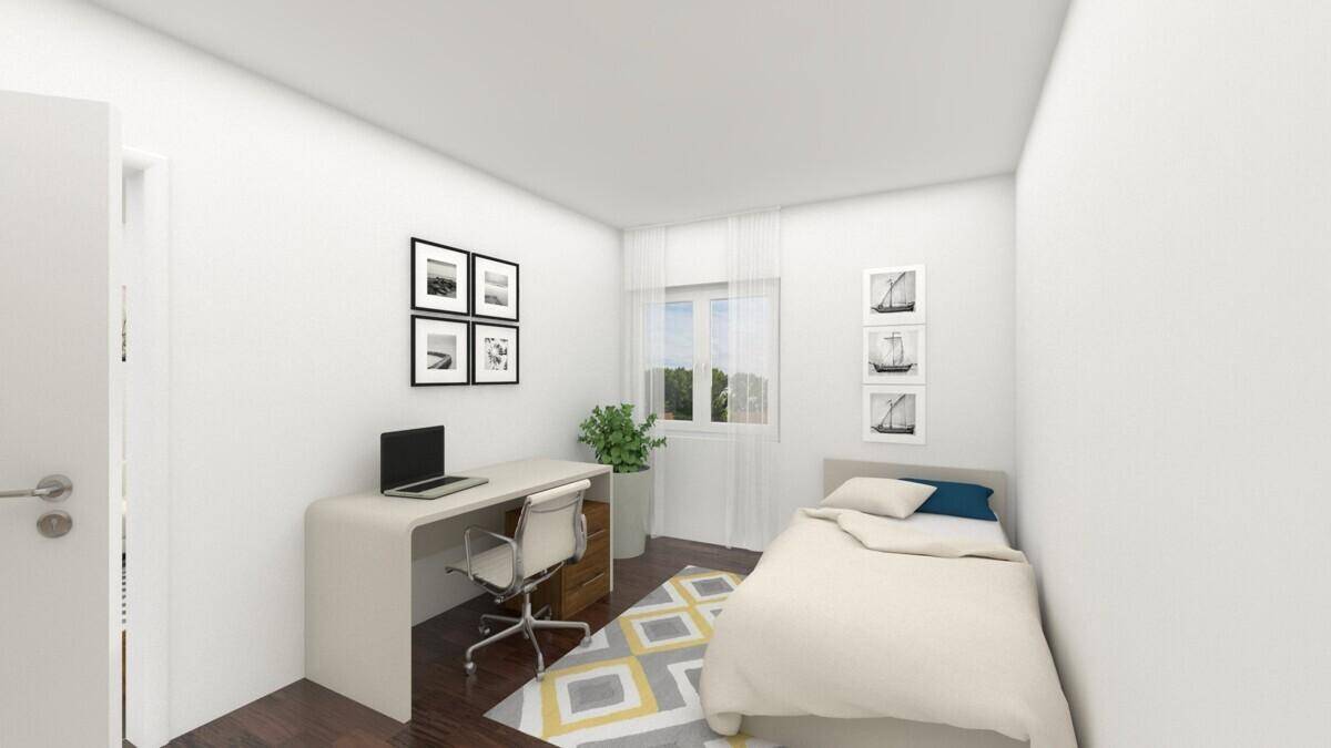 Helles Schlafzimmer mit Einzelbett, Schreibtisch und Fenster mit Blick ins Grüne.