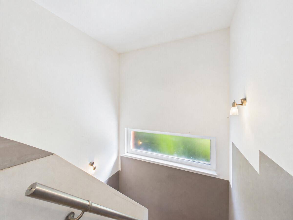 Treppenhaus mit kleinem Fenster, das für natürliches Licht sorgt.