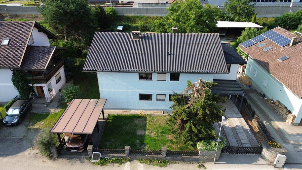 Luftaufnahme des Wohnhauses mit Garten, Carport und umliegenden Gebäuden in ländlicher Umgebung.