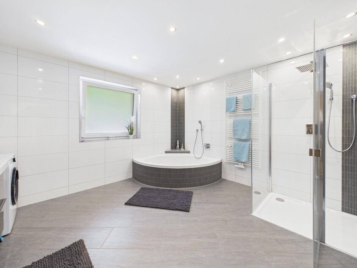 Großes, modernes Badezimmer mit Eckbadewanne, begehbarer Dusche und Waschmaschine.