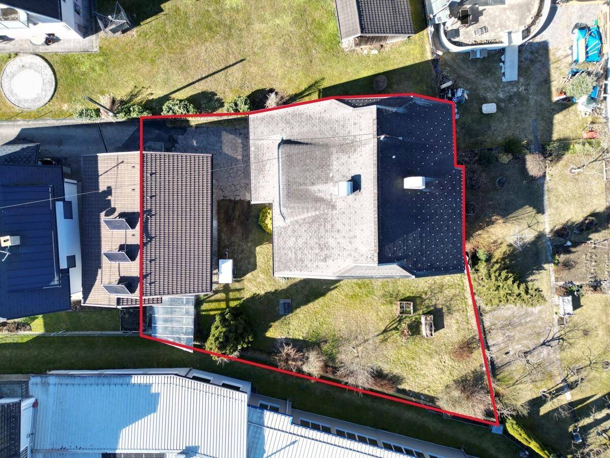 Luftaufnahme des Grundstücks mit Wohnhaus und Nebengebäuden, umrandet von einer roten Linie.