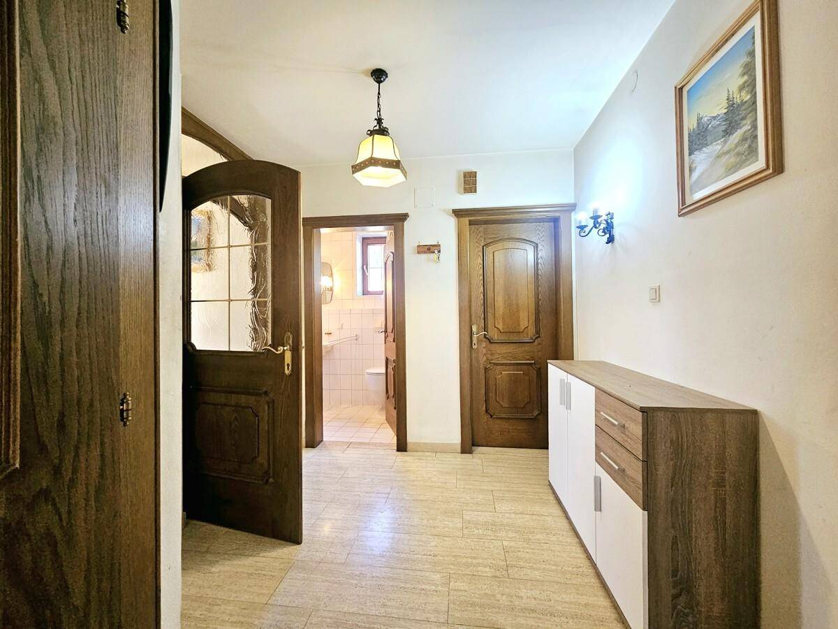 Flur mit Fliesenboden und Zugang zu weiteren Räumen, inklusive Badezimmer.