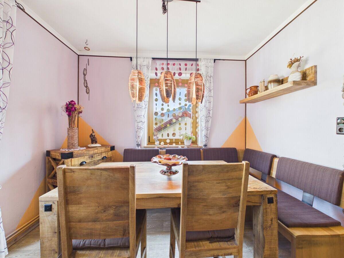 Heller Essbereich mit rustikalem Holztisch und bequemer Eckbank, ideal für Familien.