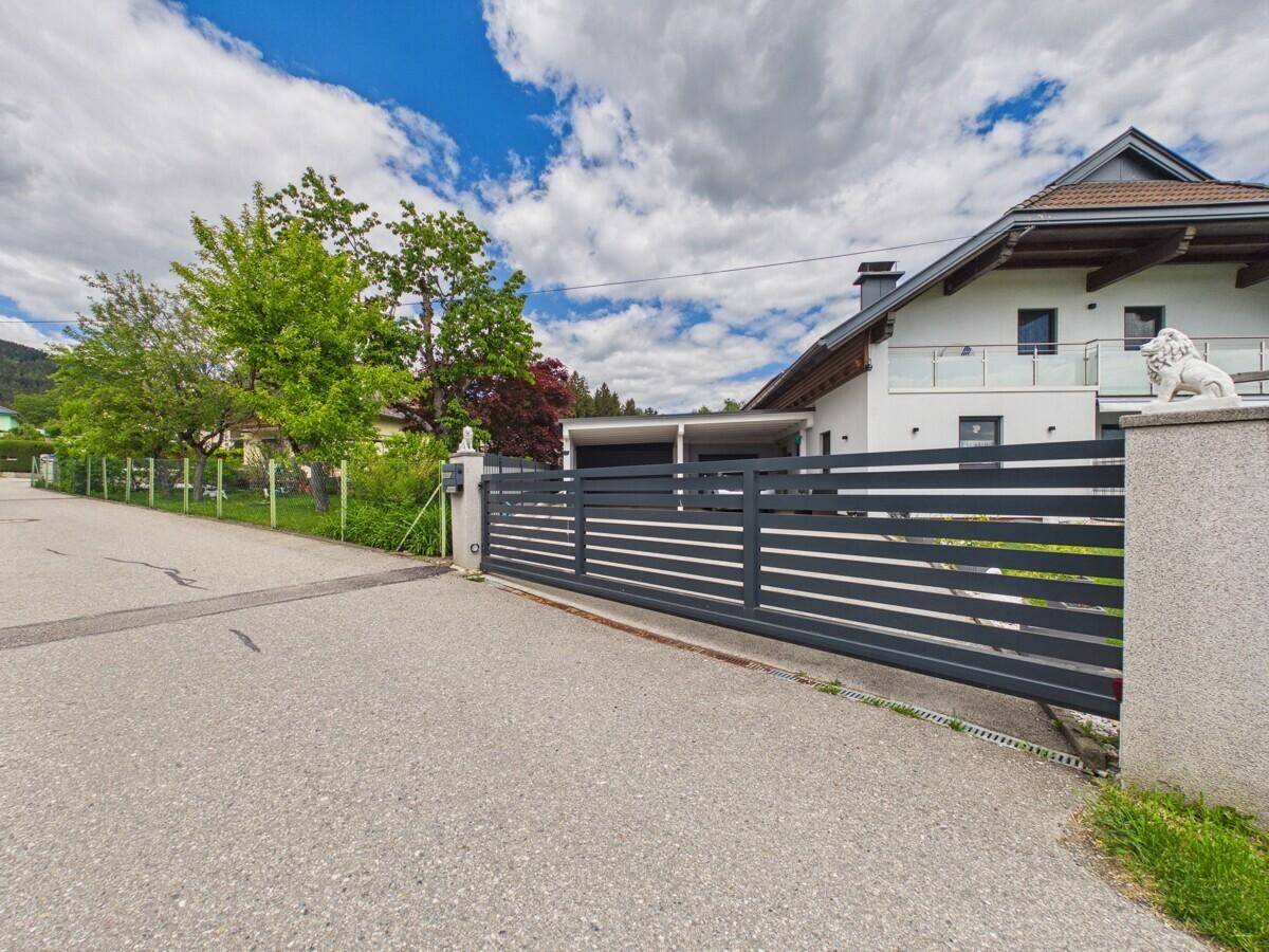Zufahrt zum modernen Einfamilienhaus mit Schiebetor und Carport.