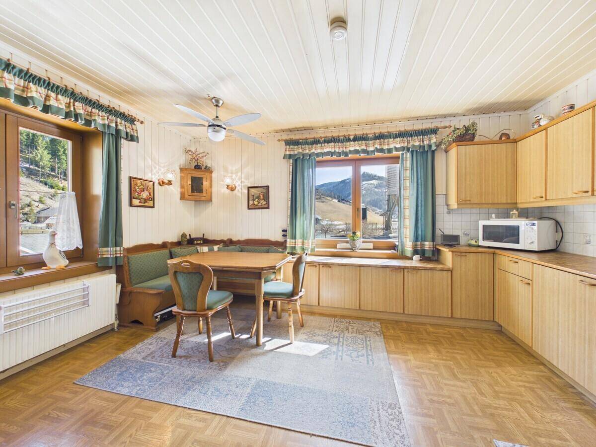 Geräumige Wohnküche im traditionellen Stil mit Essbereich und Blick auf die Berglandschaft.
