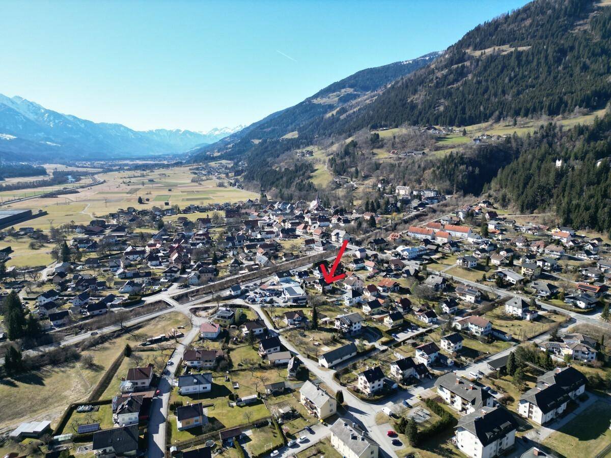 Weitläufige Luftaufnahme der Siedlung in einer Berglandschaft mit Blick auf die Umgebung.