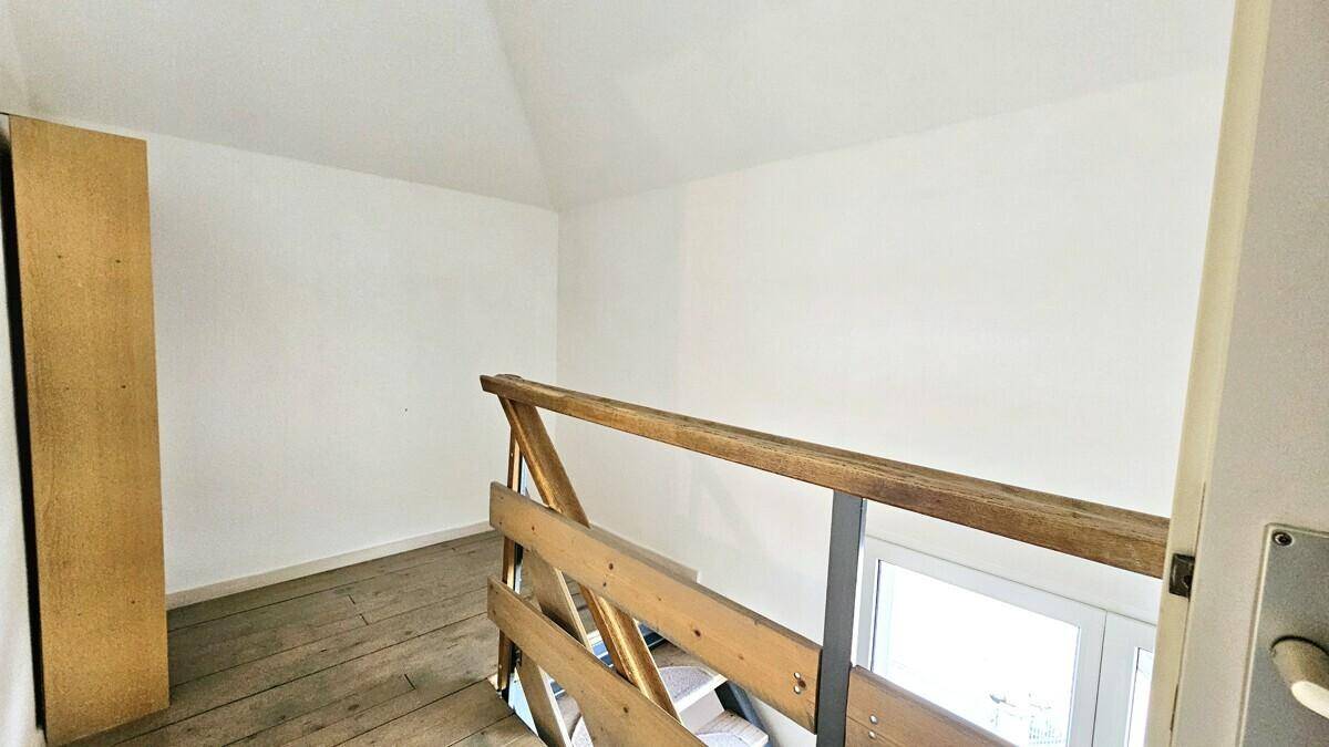 Heller Flurbereich mit Holzgeländer und Holzdielenboden unter einer Dachschräge.