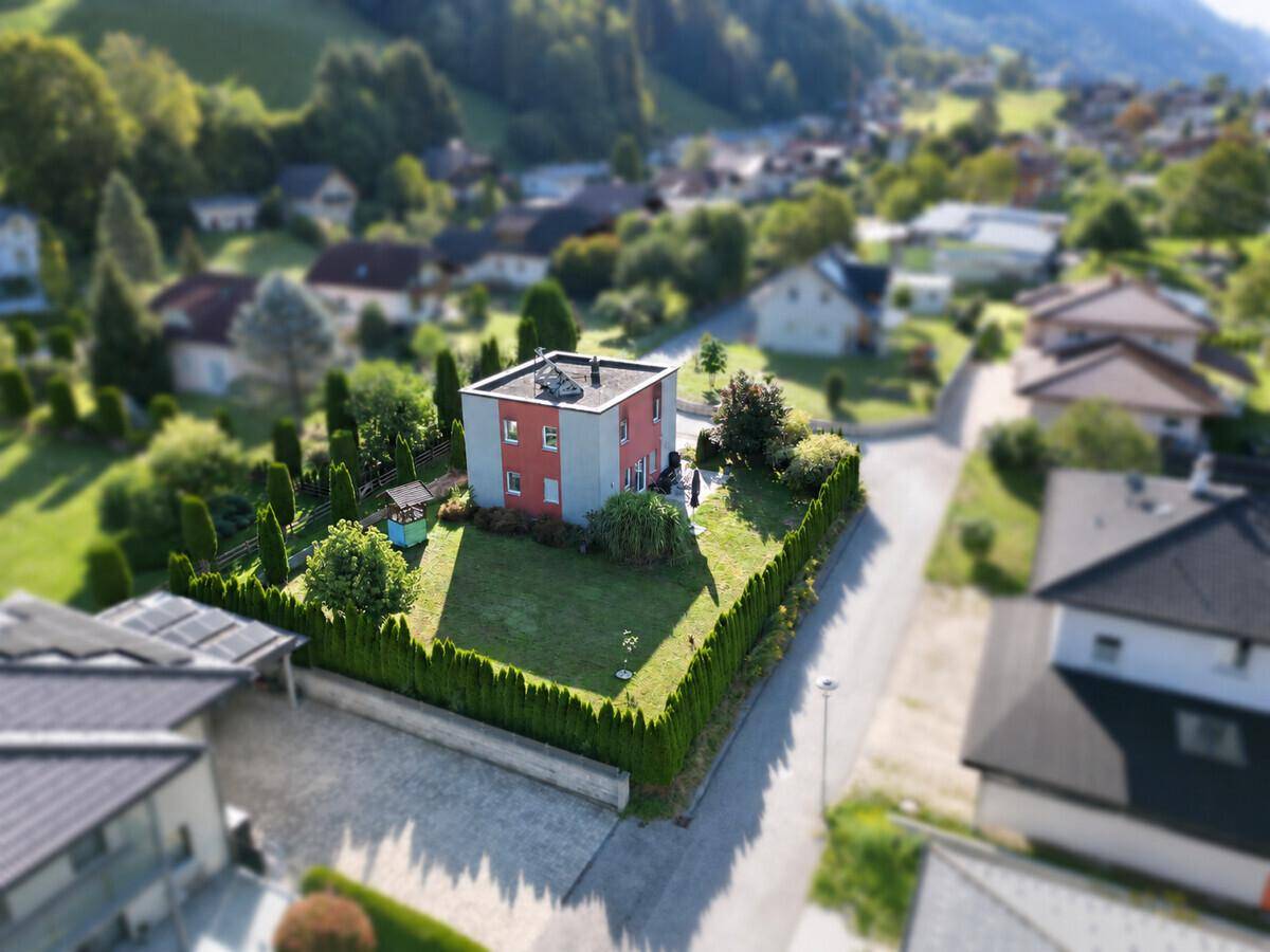 Panoramische Luftaufnahme des Hauses mit Garten, umgeben von der Nachbarschaft und Bergen.