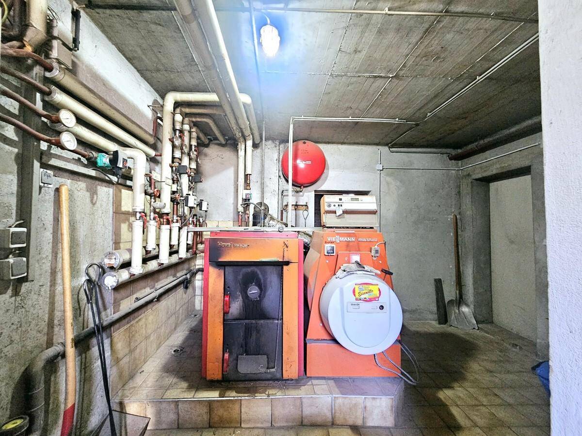 Heizungsraum im Keller mit zwei Heizkesseln und vielen Leitungen.