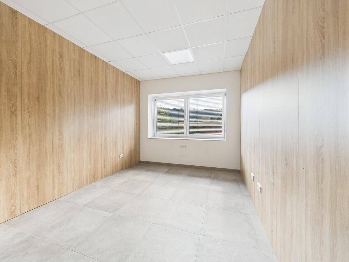 Kleines Büro mit Holzpaneelen an den Wänden und hellen Fliesen auf dem Boden.