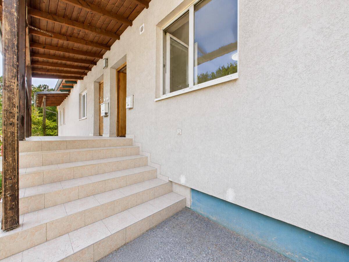 Eingangsbereich des Gebäudes mit Treppe und überdachtem Zugang zu den Wohneinheiten.