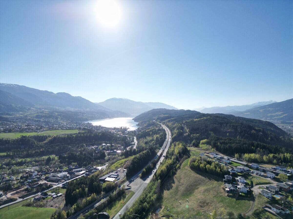 Panoramablick aus der Vogelperspektive auf die Seenlandschaft und umliegende Berge.