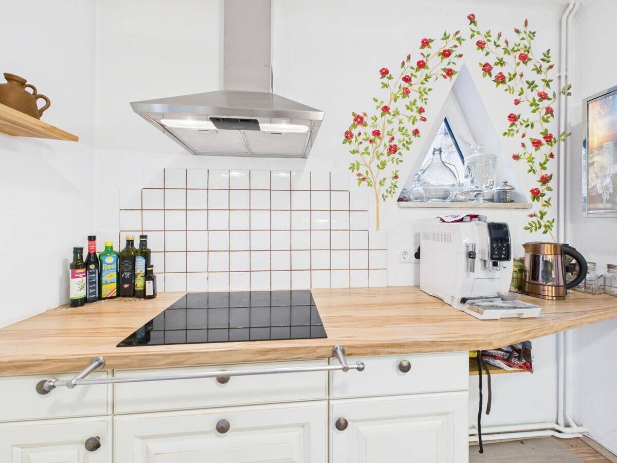 Detailansicht der Küche mit Induktionskochfeld, Kaffeemaschine und Holzarbeitsplatte.