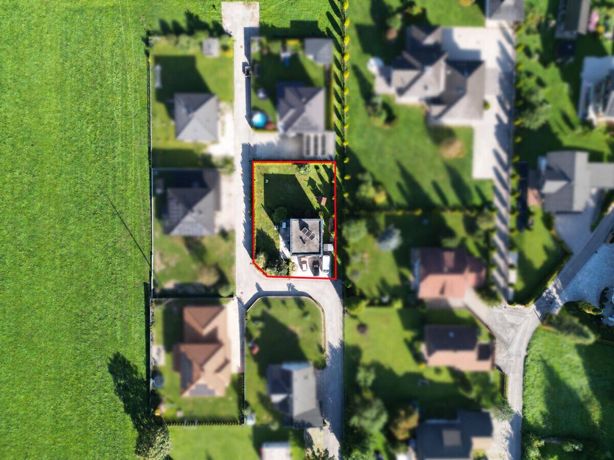 Luftaufnahme des Grundstücks mit rot umrandetem Haus und umliegender Wohnbebauung.