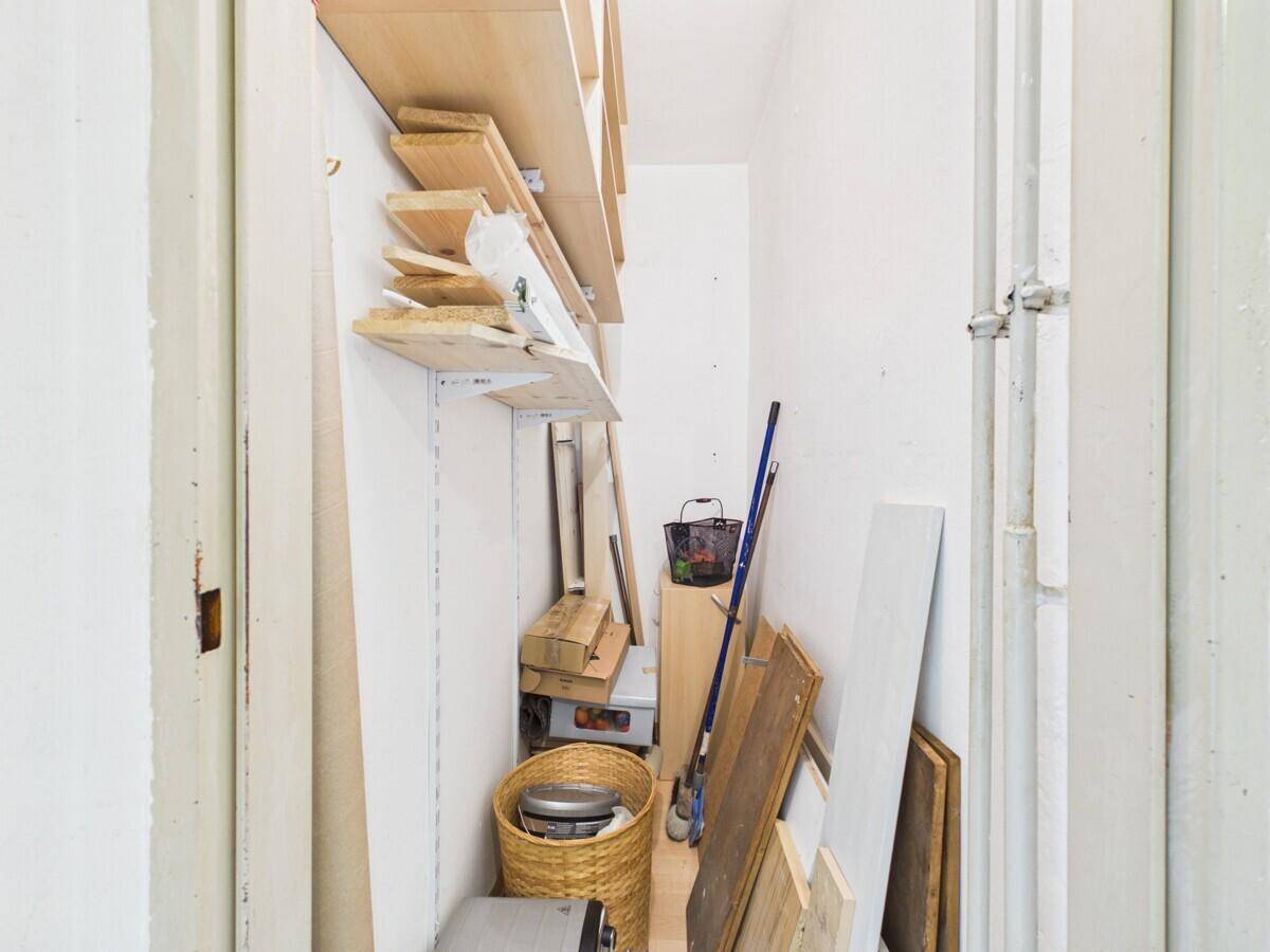 Praktischer Abstellraum mit Holzregalen und Stauraum für verschiedene Haushaltsgegenstände.