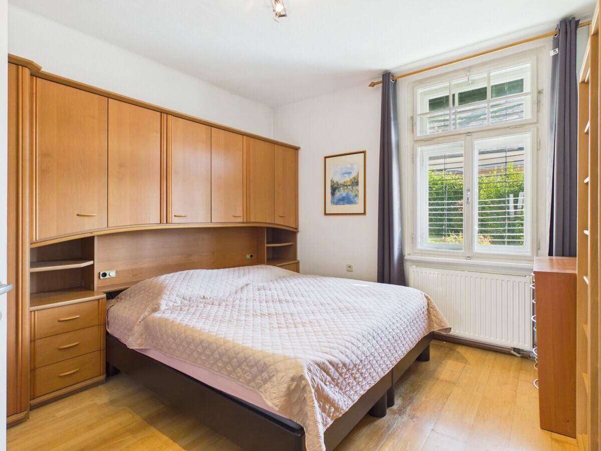 Schlafzimmer mit Einbauschränken, Doppelbett und großem Fenster.