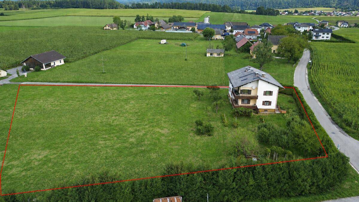 Luftaufnahme des Grundstücks mit einem Haus und umgebenden Feldern, rot umrandet.
