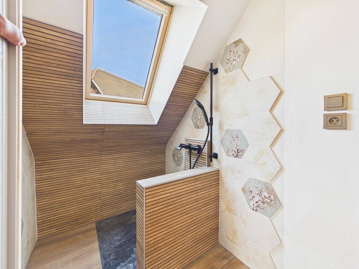 Modernes Duschbad im Dachgeschoss mit Holzverkleidung, sechseckigen Fliesen und Dachfenster.