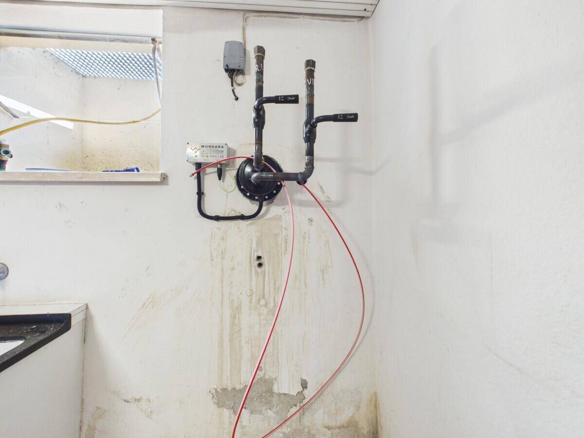 Einfacher Hauswirtschaftsraum mit Wasseranschlüssen und Waschbecken, ideal für praktische Zwecke.