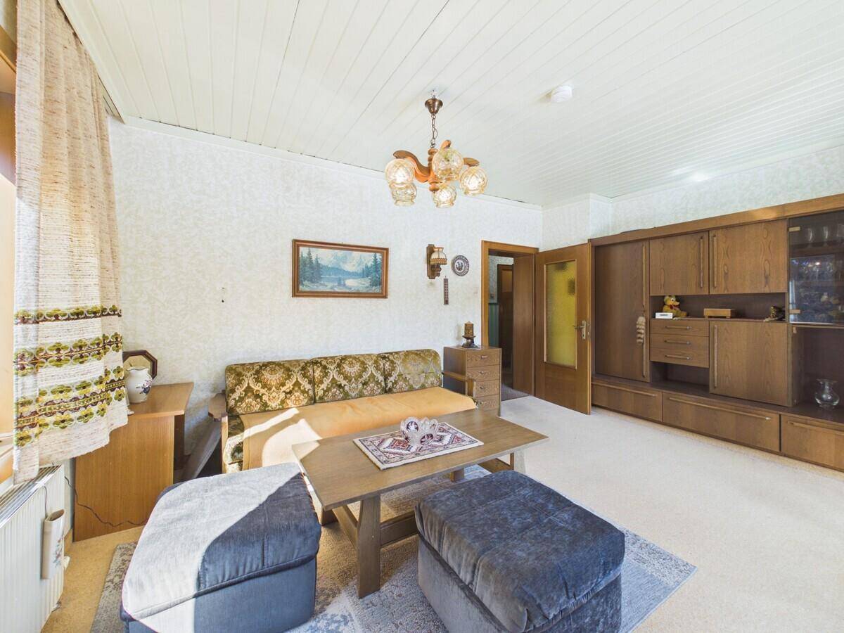 Wohnzimmer mit bequemen Sofas, Holzdecke und traditionellen Möbeln in gutem Zustand.