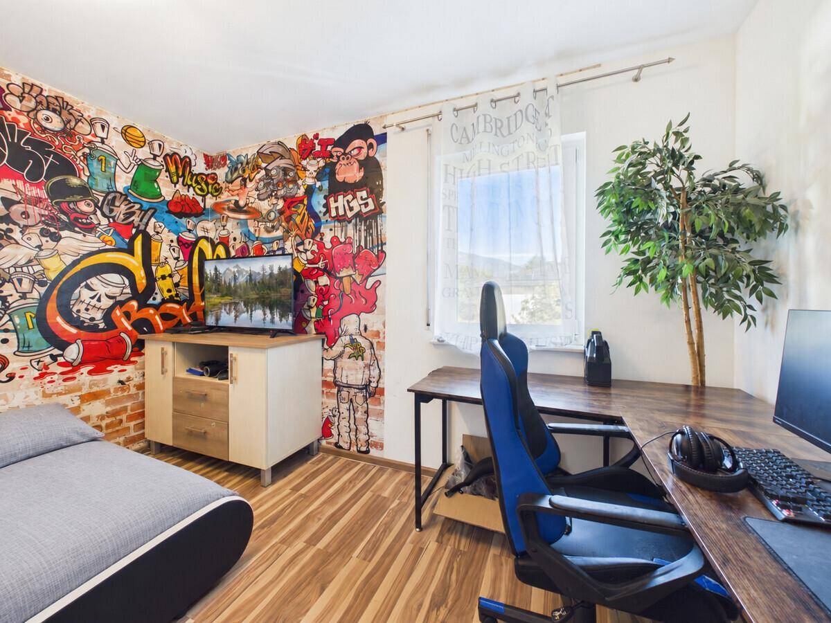 Modernes Schlafzimmer mit Schreibtisch, Gaming-Stuhl und kreativer Graffiti-Wandgestaltung.