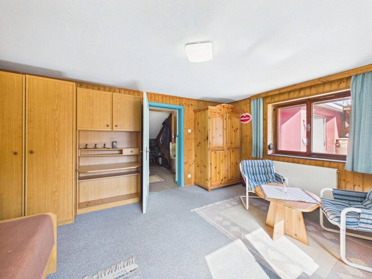 Schlafzimmer mit Holzvertäfelung, Einbauschränken und Teppichboden, in gutem Zustand.