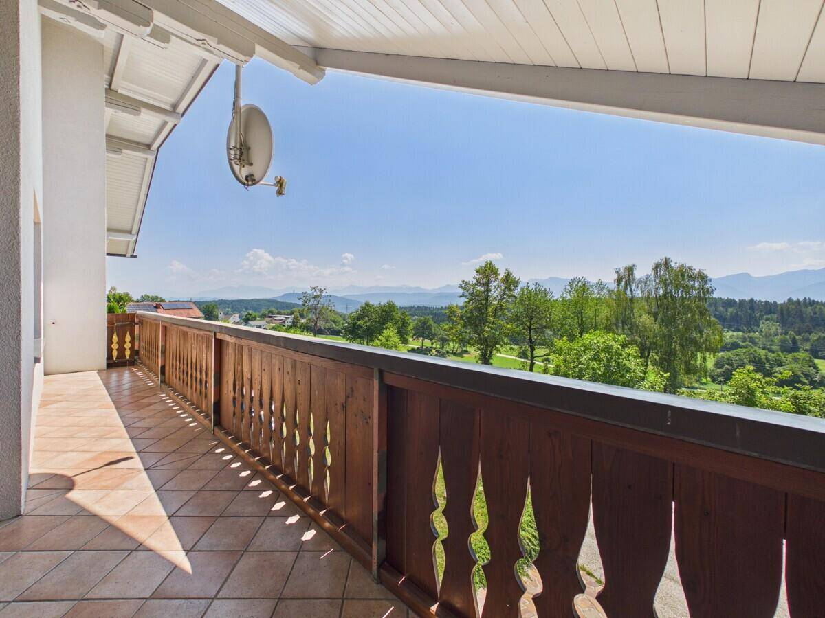 Geräumiger Balkon mit traditionellem Holzgeländer und weitem Panoramablick über die Landschaft.