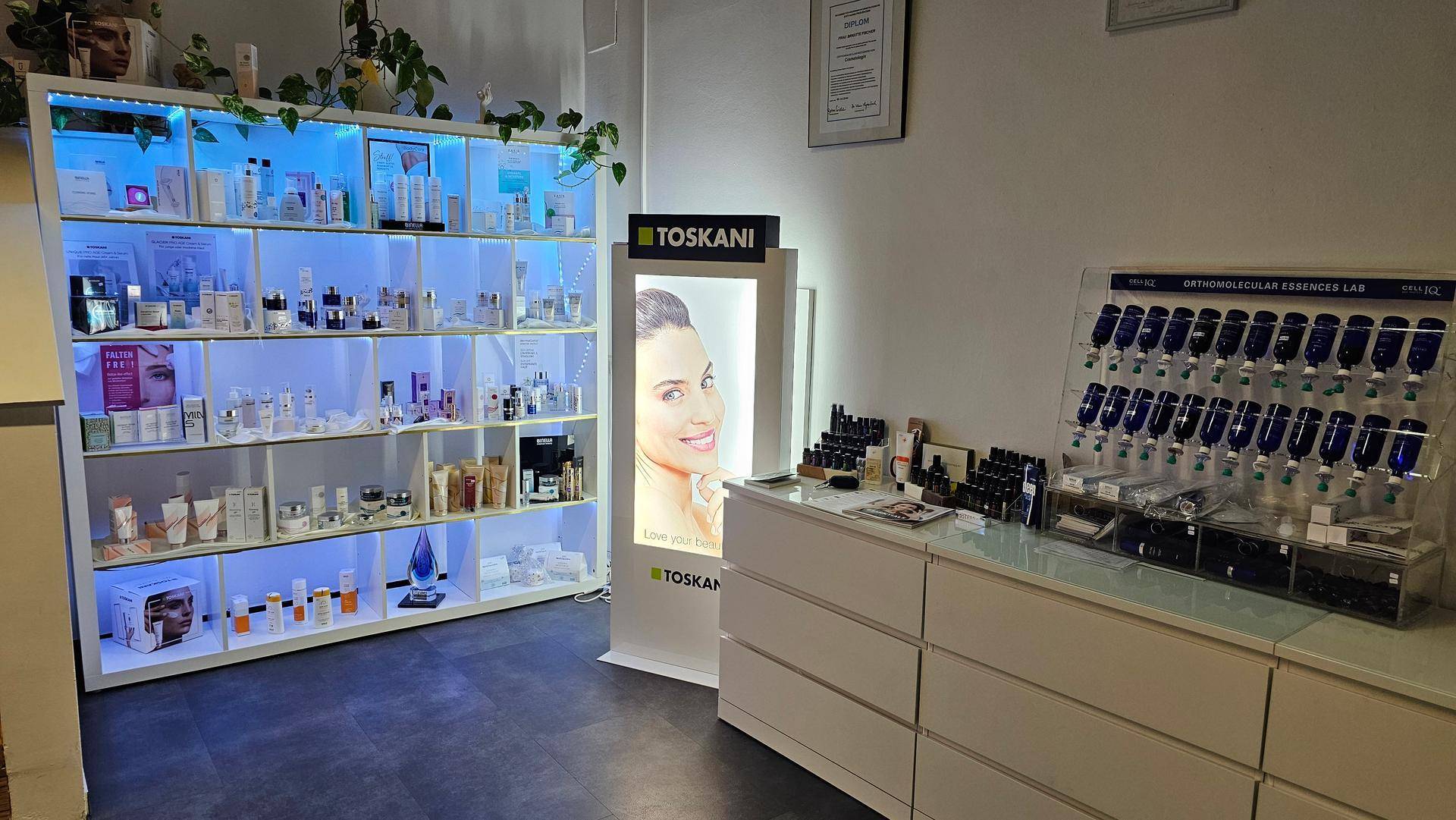 Verkaufsbereich mit beleuchteten Regalen voller Produkte und einem großen Werbedisplay in modernem Design.