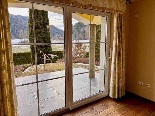 Große Schiebetüren im Wohnzimmer bieten Zugang zur Terrasse und Blick auf die Landschaft.