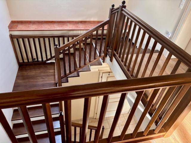 Holztreppe mit Geländer, die verschiedene Ebenen des Hauses miteinander verbindet.