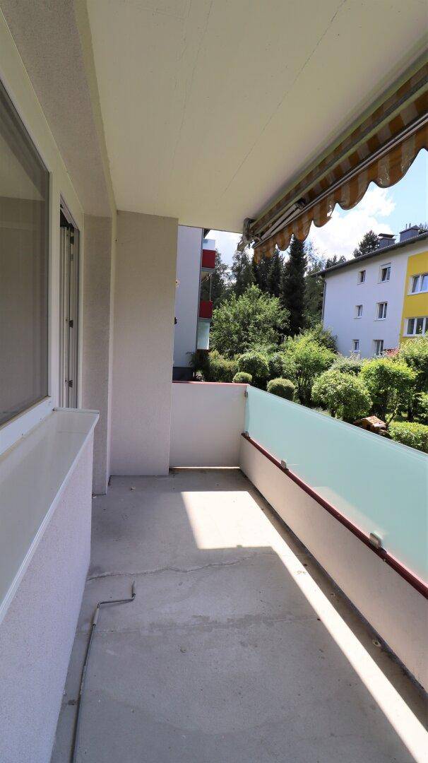 Heller Balkon mit Glasbrüstung und Markise, bietet einen angenehmen Außenbereich.